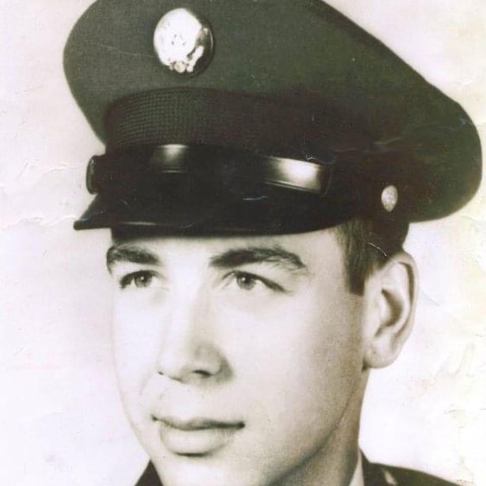 Vintage black and white portrait of a young man in a military uniform and cap.
