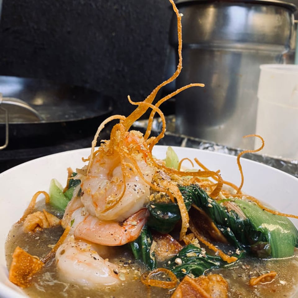 Pattaya Thai dish with shrimp, green vegetables, and crispy noodles in a savory sauce.