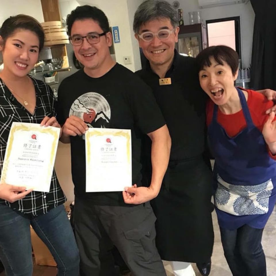 Four smiling people, two holding certificates, pose together at Pattaya Thai restaurant.